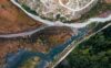 Vue aérienne de deux cours d’eau se rejoignant parmi bois et graviers