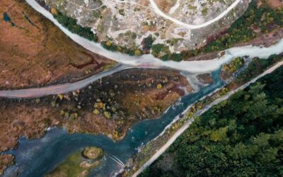Vue aérienne de deux cours d’eau se rejoignant parmi bois et graviers
